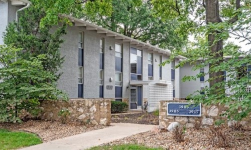 The exterior of a building near a wooded area